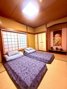 Dos camas en una habitación con dos ventanas. en 楓の宿1號館, en Osaka