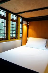 una cama en una habitación con dos ventanas en Avaiaa, en Varkala