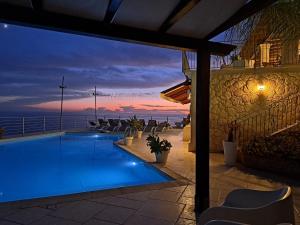 a swimming pool with a view of the ocean at night at B&B Terrazze Chiaramontane Exclusive Resort in Marina di Palma