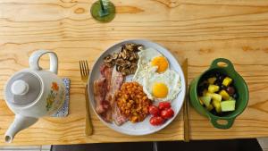 a plate of breakfast food on a wooden table at Jacaranda Escape in Pretoria +9 photos
