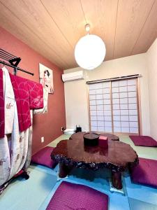 Una sala de estar con una mesa y una gran ventana. en 楓の宿1號館, en Osaka