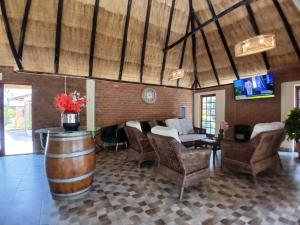 a room with a table and chairs and a barrel at Fortunesgate Lodge in Bulawayo