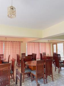 a dining room with wooden tables and chairs at White Apricot Lodge in Baltit +32 photos