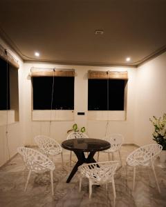 un tavolo e delle sedie in una stanza con finestre di Narayani Villa a Udaipur