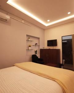 una camera da letto con un letto, una scrivania e una televisione di Narayani Villa a Udaipur