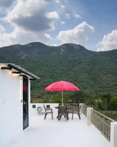 un patio con un tavolo e un ombrellone rosso di Narayani Villa a Udaipur Altre 19 foto