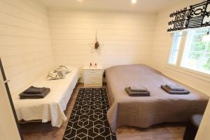a room with two beds in a small room at Villa Moinalahti in Sirkkakoski
