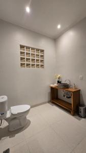a bathroom with a toilet and a wooden table at Adyatma Ubud in Ubud +39 photos