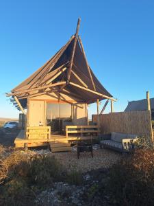 a wooden gazebo with a bench and a table at Trekosglamping luxury tents  +9 photos