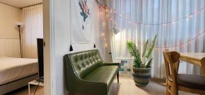 a bedroom with a green chair and a table with a plant at 대게, Private Kintex Daehwadong in Goyang