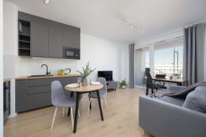 a kitchen and living room with a table and a couch at Warsaw Elegant Apartment with Parking and Balcony by Noclegi Renters in Warszawa