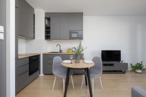 a kitchen with a table and chairs in a room at Warsaw Elegant Apartment with Parking and Balcony by Noclegi Renters in Warszawa