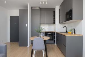 a kitchen with a wooden table and a counter top at Warsaw Elegant Apartment with Parking and Balcony by Noclegi Renters in Warszawa