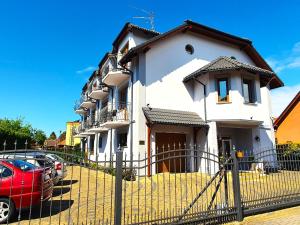 a house with a red car parked in front of it at Astra Dziwnówek Dom Gościnny in Dziwnówek