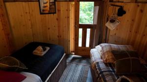 een slaapkamer met een bed en een bank in een hut bij Nature Escape in an Alaskan Glamping Village for Family Fun in Bear Creek