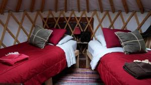 twee bedden in een kamer met rode en witte lakens bij Nature Escape in an Alaskan Glamping Village for Family Fun in Bear Creek