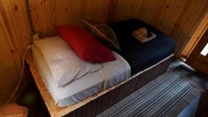 een bed in een houten kamer met twee kussens erop bij Nature Escape in an Alaskan Glamping Village for Family Fun in Bear Creek +30 foto's