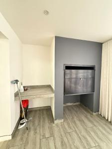 a living room with a desk and a television on a wall at Haven Luxury Apartment in Windhoek +4 photos