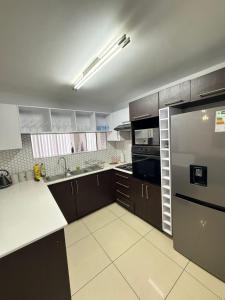 a kitchen with brown cabinets and a stainless steel refrigerator at Haven Luxury Apartment in Windhoek