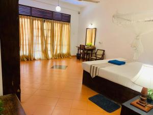 a bedroom with a bed and a table and chairs at Westrom Villa Ocean Front in Bentota