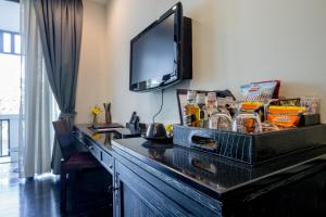 a room with a counter with alcohol bottles and a tv at Aruntara Riverside Boutique Hotel in Chiang Mai