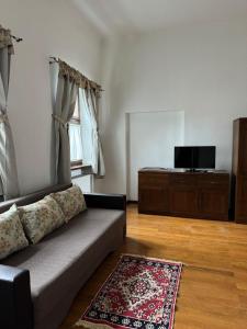 a living room with a couch and a flat screen tv at Guesthouse Cetate in Oradea