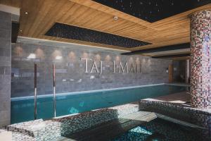 a swimming pool with a sign that reads tar immortal at Hôtel Taj-I Mah by Les Etincelles in Arc 2000
