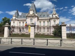 a large white building with a fence in front at ArtPartment Downtown in Craiova