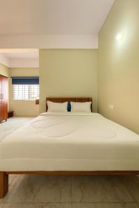 a bedroom with a large white bed in a room at Rk Resorts in Bangalore