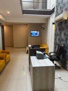 a office with a desk and chairs and a tv at Hotel Maria in Dera Bassi