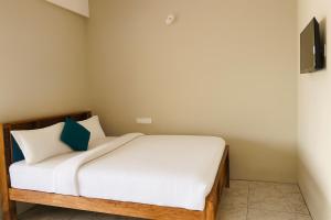 a bedroom with a bed with white sheets and blue pillows at Rk Resorts in Bangalore