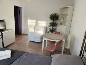 a living room with a table and a chair at Apartament Przytulny przy plaży in Sopot