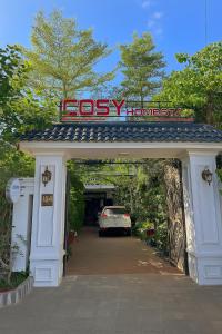 Une voiture est garée sous un garage avec un panneau. dans l'établissement Cosy Homestay Huế, à Hue