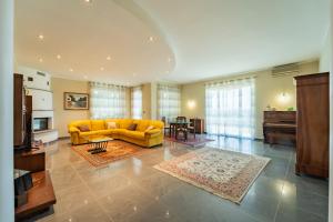 a living room with a yellow couch and a table at Villa with Pool in Unesco, 4 Room, Parking e Free WiFi in San Damiano dʼAsti