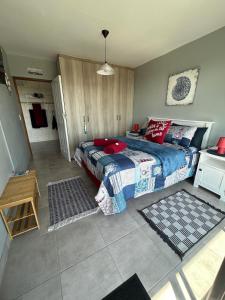 een slaapkamer met een bed met een blauwe deken en rode kussens bij Seebossie in Struisbaai +3 foto's