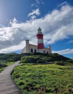een rood-witte vuurtoren op een heuvel met een pad bij Seebossie in Struisbaai