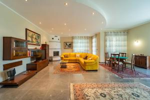 a living room with a yellow couch and a table at Villa with Pool in Unesco, 4 Room, Parking e Free WiFi in San Damiano dʼAsti