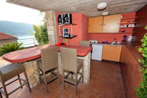 a kitchen with a counter and a table with chairs at Seaside house with a swimming pool Mokosica, Dubrovnik - 8583 in Mokošica