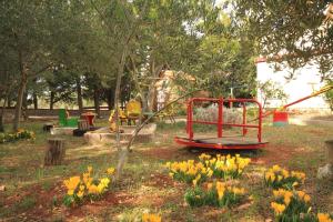a playground in a park with yellow flowers at Apartments with parking space Ugljan - 8479 in Ugljan