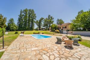a backyard with a pool and chairs and a house at Villa with Pool in Unesco, 4 Room, Parking e Free WiFi in San Damiano dʼAsti