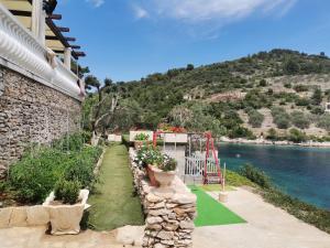 een tuin met speeltuin aan het water bij Apartments by the sea Cove Mikulina Luka, Korcula - 9181 in Vela Luka