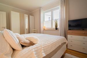 a bedroom with a bed with pillows and a television at SILBERhERZ in Freiberg
