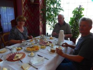 Un groupe de personnes assises autour d'une table avec de la nourriture dans l'établissement Twin Room Knezevi Vinogradi 15024d, à Kneževi Vinogradi