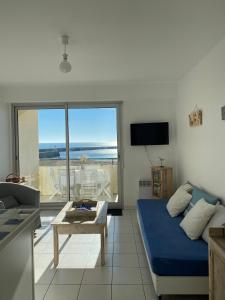 ein Wohnzimmer mit einem blauen Bett und Meerblick in der Unterkunft Au Bord De L'océan Vue Mer in Saint-Gilles-Croix-de-Vie