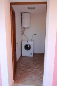 a laundry room with a washing machine in a room at Apartments by the sea Veli Rat, Dugi otok - 11525 in Veli Rat