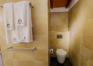 a bathroom with a shower with a toilet and towels at Gin Villa in Kammala South