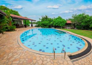 a large swimming pool with blue water in a yard at Gin Villa in Kammala South