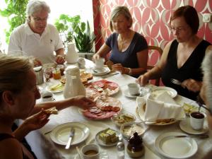 eine Gruppe von Menschen sitzt um einen Tisch herum und isst in der Unterkunft Rooms with a parking space Knezevi Vinogradi, Baranja - 15024 in Kneževi Vinogradi + 9 Fotos
