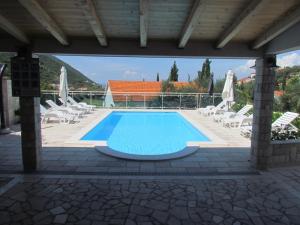 een zwembad op een patio met stoelen en parasols bij Family-friendly apartments with swimming pool Trpanj, Peljesac - 15603 in Trpanj
