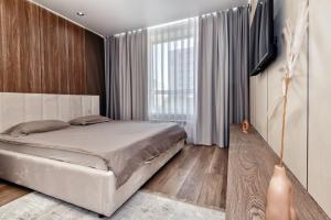 Отличный вариант рядом с Новым вокзалом في أستانا: غرفة نوم بها سرير ونافذة كبيرة